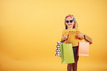 Child with shopping bags. Lady in a yellow sweater