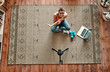 © Valerii Apetroaiei - Athletic woman blogger in sportswear sits on the floor with dumbbells and a laptop and shoots video on camera as she does exercises at home in the living room. Sport and recreation concept. Top view.
