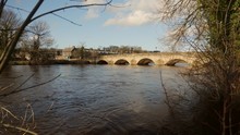 A Flooded River In Yorkshire Showing The High Water Levels Under A Bridge Flowing Quite Rapidly