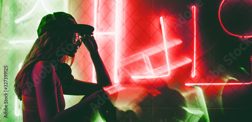 Cuadros en Lienzo Sillhoutte of hip-hop girl in cap at the neon light