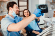 © Тарас Нагирняк - Dentistry and healthcare concept, male dentist showing teeth x-ray to female patient at dental clinic room.