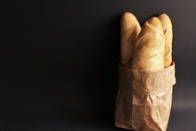 Baguette Bread In Brown Paper Bag Photo Isolate On Black Front View 