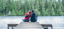 Guy And A Girl Sit Hugging On The Pier Of A Beautiful Lake. The Concept Of Love, The Summer Mood , Banner