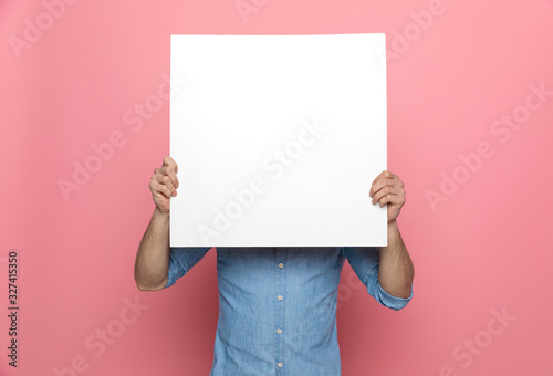 Fotografía young casual guy hiding behind empty board