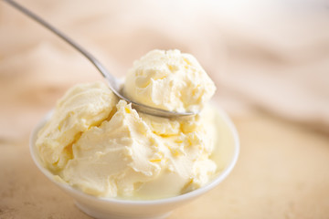 Mascarpone cream cheese close-up. Mascarpone Italian soft milk cream closeup, in wooden spoon. Homemade ice cream, yoghurt.