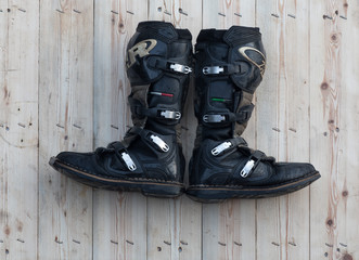 Wall Mural - black leather biker boots on black wooden background