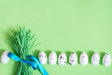 Easter Background With Eggs And Bouquet Of Green Grass. White Eggs Pattern . Holiday Flat Lay Composition, Funny Easter Concept.Blue Ribbon, Green Background.
