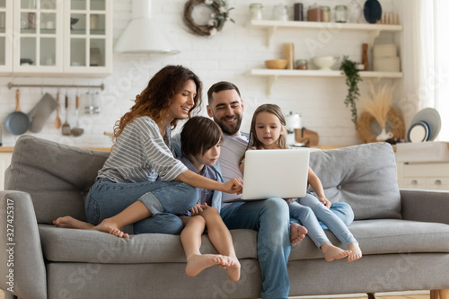 Fotomural Happy family with kids sit on couch using laptop