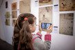 © Maria - Curious girl exploring a contemporary art exhibition with augmented reality mobile application