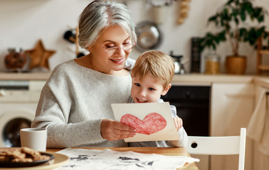 Wall Mural - happy family grandson child congratulates grandmother on holiday and gives card.