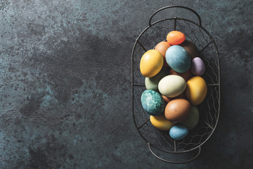 Easter background. Homemade natural diyed easter eggs in a basket and space for a text