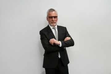 looking perfect. portrait of confident mature businessman in eyeglasses keeping arms crossed and loo