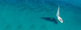 Aerial drone ultra wide photo of beautiful sail boat sailing in tropical exotic bay with emerald clear sea