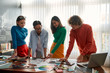 © Svitlana - Sharing insights. Professional team of young designers working on a new project together and discussing ideas while standing in the modern and bright office. Creative agency