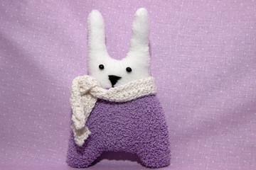 Cute handmade toy textile bunny on background