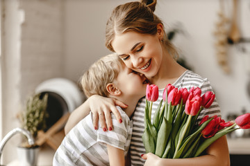 happy mother's day! child son gives flowers for  mother on holiday