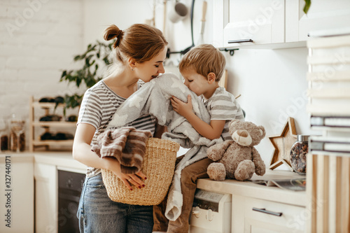 Fotografía Happy family mother housewife and child in laundry with washing machine