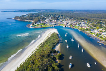 Wall Mural - Aerial drone view of boats and yachts moored on Currambene Creek at Huskisson, Jervis Bay on the New South Wales South Coast, Australia, on a bright sunny day   