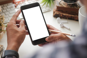 Cropped shot view of man hands holding smart phone with blank copy space screen for your text message or information content, female reading text message on cell telephone during in urban setting. 