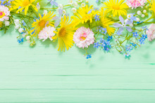 Frame Of Beautiful Flowers On Green Wooden Background