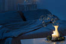 Night Interior Of Bedroom With Flowers And Burning Candles