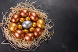 Fototapeta Tulipany - Easter golden eggs in the nest, preparation for the holiday