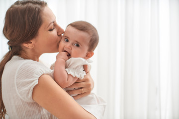 happiness mother! loving mother embracing and kissing her child on white.