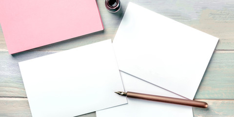 Wall Mural - Stationery mock-up with an ink bottle and a nib pen. Blank greeting cards or invitations, overhead panoramic shot