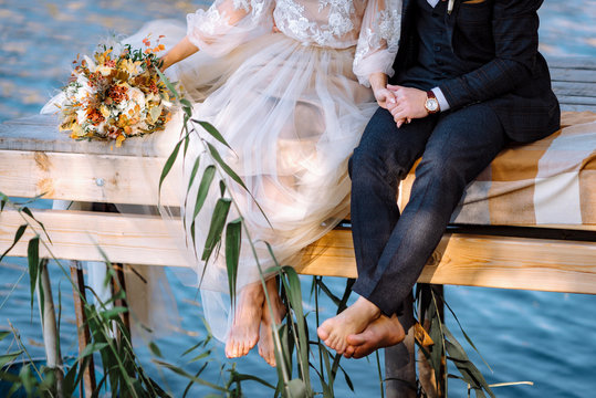 feet of the bride and groom, bare feet, on the bridge