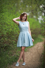 Girl in blue dress in green park