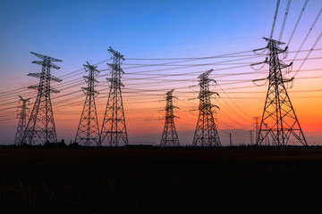 Canvas Print - High voltage power tower and beautiful nature landscape at sunset