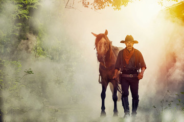 The silhouette of a cowboy man, with a horse on a farm at dusk, sunset