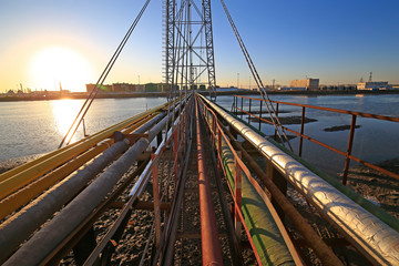 The oil pipeline on the bridge, silhouetted in the sunset