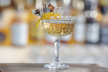 Wall Mural - A glass of beautifully decorated whiskey cocktail with an orange peel on the bar counter	