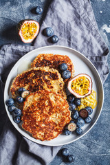 Canvas Print - Oatmeal pancakes with honey, fruits and berries, blue background, top view. Healthy vegan food concept.