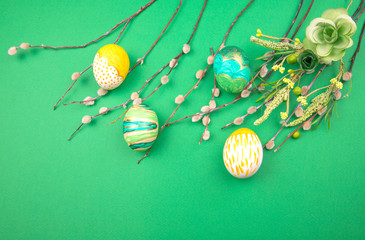 Wall Mural - handmade painted Easter eggs with spring branches with buds on a green background