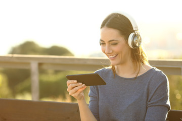 Sticker - Happy woman watching videos on her phone at the park