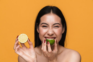 Wall Mural - Beauty portrait of young half-naked woman smiling and eating lemon