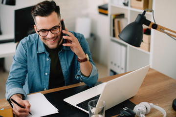 businessman in office. handsome man talking on phone at work.