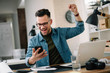 © JustLife - Handsome businessman celebrating won. Portrait of businessman in office.