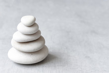 Stack Of White Pebbles On A Neutral Light Grey Background As Balance And Wellness Concept