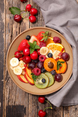 Wall Mural - bowl of mixed fruits- berry, cherry, apricot, kiwi, strawberry, banana- healthy dessert