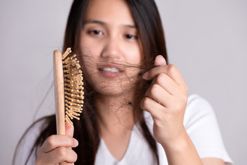 Wall Mural - Healthy concept. Woman show her brush with damaged long loss hair and looking at her hair.