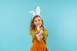 © Drobot Dean - Photo of joyful blonde girl smiling and holding colorful eggs