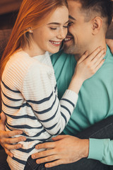 Wall Mural - Red haired caucasian girl with freckles is held by her lover during a warm morning together