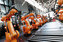 Robotic Arms Along Assembly Line In Modern Factory.
