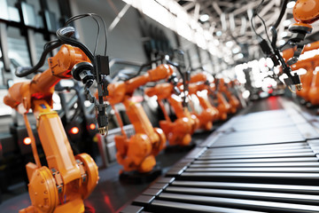 Wall Mural - Robotic arms along assembly line in modern factory.