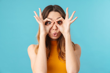 Portrait of beautiful joyous woman looking through finger holes