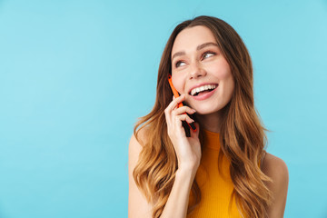 Wall Mural - Portrait of beautiful joyous woman smiling and talking on cellphone