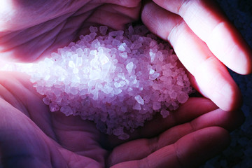 sea salt in hands with light, for health close-up